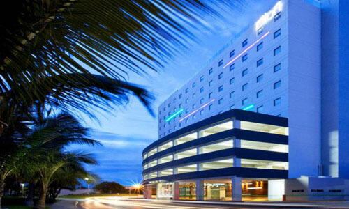 Picture of a beautiful building in Cancun, Mexico.  The picture was taken near sunset and shows blue, baby blue and white colors.