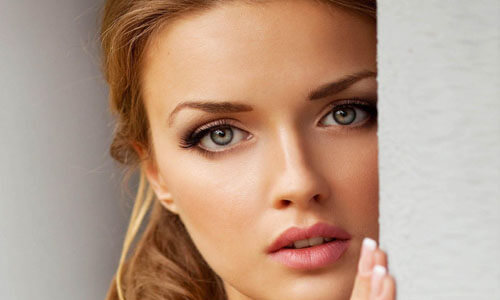 Close-up picture of a beautiful woman, happy with her eyelid lift in Cancun, Mexico.  The woman has medium length brown hair and is looking directly at the camera.