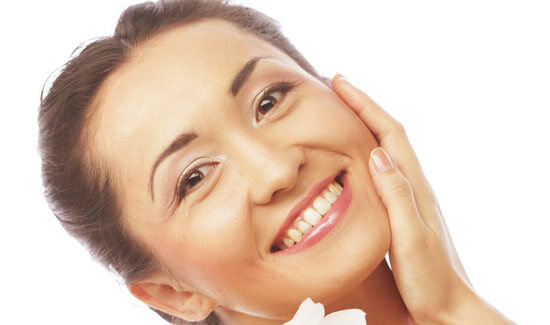 Picture of a woman, facing the camera and happy with her perfect face lift with neck lift procedure she with Cancun MedVentures in beautiful Cancun, Mexico.   The woman has her hand to the side of her face indicating her happiness with the face lift with neck lift.